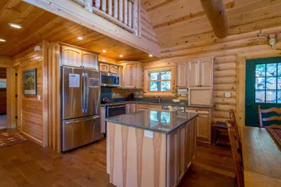 a kitchen with a refrigerator and a counter top at Armstrong Home in Estes Park