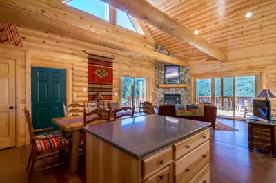 a kitchen and living room of a log cabin at Armstrong Home in Estes Park