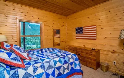 a bedroom with a bed and an american flag on the wall at Armstrong Home in Estes Park