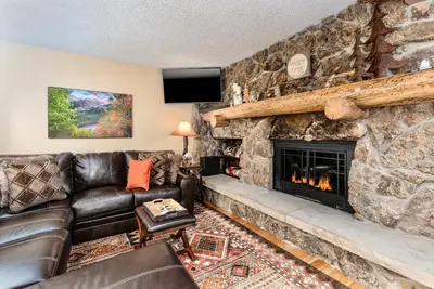 a living room with a stone fireplace at Divine Condominium 3 Bedroom condo in Estes Park