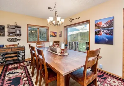 a dining room with a wooden table and chairs at Divine Condominium 3 Bedroom condo in Estes Park