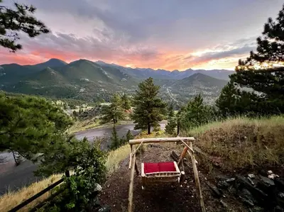 a red chair sitting on the side of a mountain at Divine Condominium 3 Bedroom condo in Estes Park