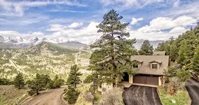 a house on a dirt road with a tree at Divine Condominium 3 Bedroom condo in Estes Park
