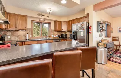a large kitchen with wooden cabinets and a large counter at Divine Condominium 3 Bedroom condo in Estes Park