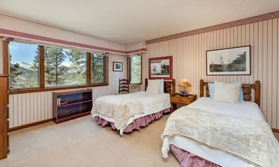 a bedroom with two beds and a fireplace at Macmillan Home in Estes Park