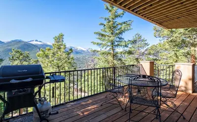 a deck with a grill and a table and chairs at Cedar Lower Condominium 2 Bedroom condo in Estes Park