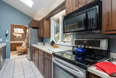 a kitchen with a stove and a microwave at Cedar Upper Condominium 3 Bedroom condo in Estes Park