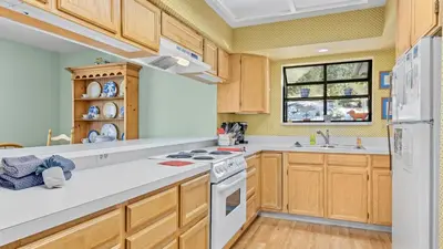 a kitchen with wooden cabinets and a white stove top oven at Werlein Condominium 4 Bedroom condo in Estes Park