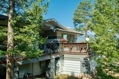 a house with a balcony with trees at Werlein Condominium 4 Bedroom condo in Estes Park