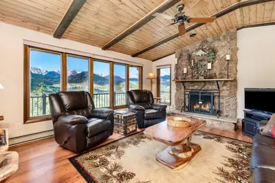 a living room with leather chairs and a fireplace at Stevenson Home in Estes Park
