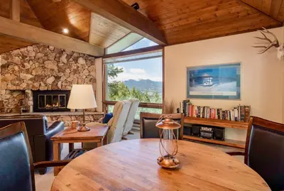 a dining room with a table and chairs and a stone wall at Griffin Family Condominium 4 Bedroom condo in Estes Park