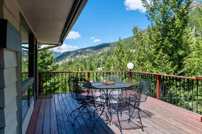 a patio with a table and chairs on a deck at Griffin Family Condominium 4 Bedroom condo in Estes Park