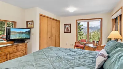 a bedroom with a bed and a flat screen tv at Griffin Family Condominium 4 Bedroom condo in Estes Park