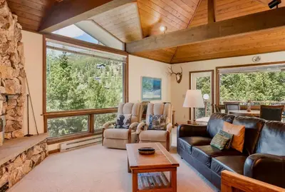 a living room with leather furniture and a stone fireplace at Griffin Family Condominium 4 Bedroom condo in Estes Park