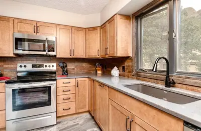a kitchen with wooden cabinets and a sink at Alleman North Condominium 3 Bedroom condo in Estes Park