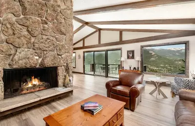 a living room with a large stone fireplace at Alleman North Condominium 3 Bedroom condo in Estes Park