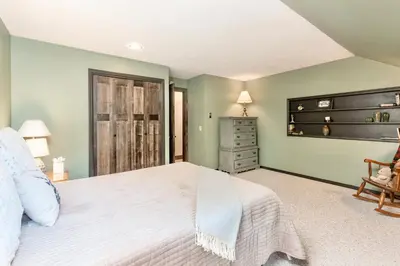 a bedroom with a white bed and a chair at Alleman North Condominium 3 Bedroom condo in Estes Park