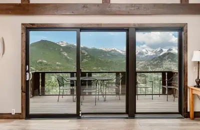 a room with sliding glass doors with a view of mountains at Alleman North Condominium 3 Bedroom condo in Estes Park