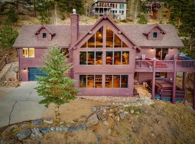 a large pink house with a large deck at Awestruck Home in Estes Park