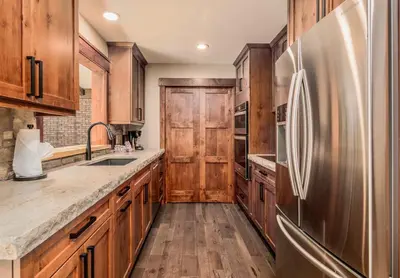 a kitchen with wooden cabinets and a stainless steel refrigerator at Breiding Upper Condominium 2 Bedroom condo in Estes Park