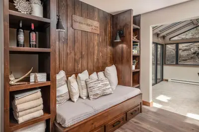a room with a wooden wall with a bench with pillows at Breiding Upper Condominium 2 Bedroom condo in Estes Park