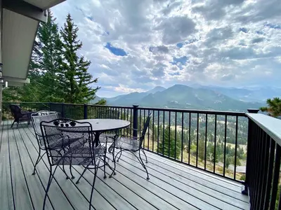 a table and chairs on a deck with a view at Breiding Upper Condominium 2 Bedroom condo in Estes Park
