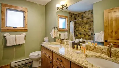a bathroom with a tub and a toilet and a sink at Mapes Home in Estes Park