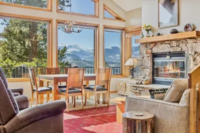 a living room with a table and a fireplace at Dances With Wolves Condominium 3 Bedroom condo in Estes Park