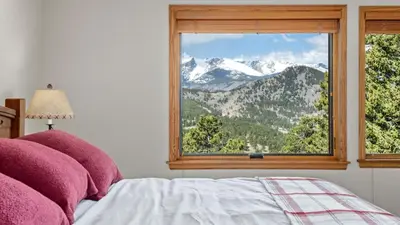 a bedroom with a window with a mountain view at Dances With Wolves Condominium 3 Bedroom condo in Estes Park