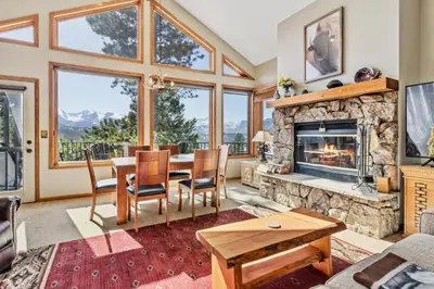 a living room with a table and a fireplace at Dances With Wolves Condominium 3 Bedroom condo in Estes Park