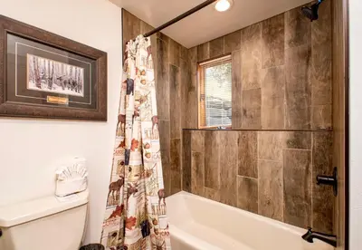 a bathroom with a tub and a shower curtain at Dances With Wolves Condominium 3 Bedroom condo in Estes Park