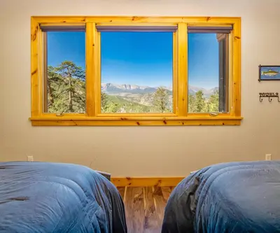 a window in a bedroom with a view of the mountains at Serenity Condominium 3 Bedroom condo in Estes Park