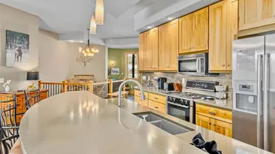 a kitchen with wooden cabinets and a large counter top at Garlands' Alpine Lodge Condominium 3 Bedroom condo in Estes Park