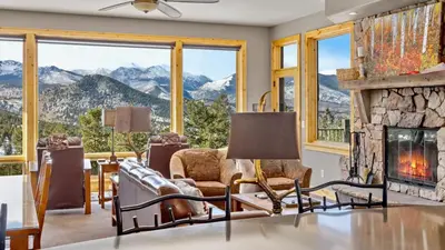 a living room with a fireplace and mountains at Garlands' Alpine Lodge Condominium 3 Bedroom condo in Estes Park