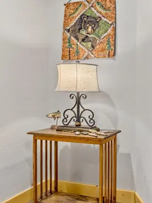 a table with a lamp and a picture of a cat at Garlands' Alpine Lodge Condominium 3 Bedroom condo in Estes Park