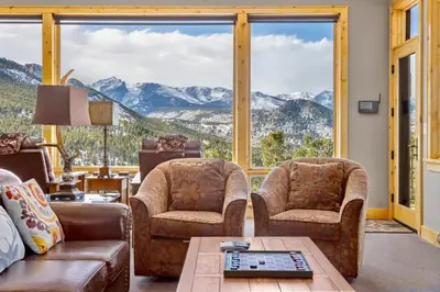 a living room with a couch and chairs and large windows at Garlands' Alpine Lodge Condominium 3 Bedroom condo in Estes Park