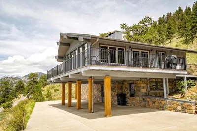 a house on pillars with a balcony on top at Kintzle Home in Estes Park
