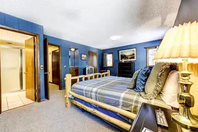 a bedroom with blue walls and a bed with a lamp at Salmans Bear Cove Home in Estes Park