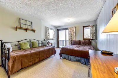 a bedroom with two beds and a table and window at Salmans Bear Cove Home in Estes Park