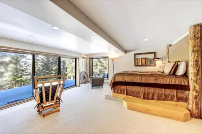 a bedroom with a bed and a large window at Salmans Bear Cove Home in Estes Park