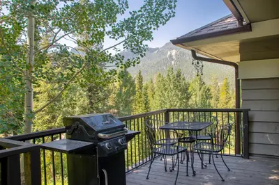 a balcony with a grill and a table and chairs at Adams Condominium 2 Bedroom condo in Estes Park