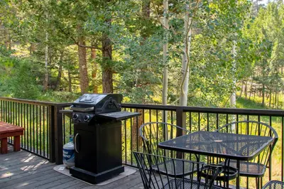 a trash can and a table on a deck at Adams Condominium 2 Bedroom condo in Estes Park