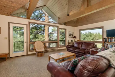 a living room with leather furniture and large windows at Adams Condominium 2 Bedroom condo in Estes Park