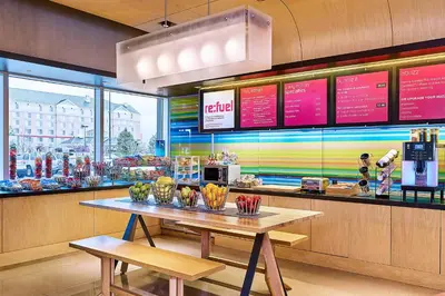 a fast food restaurant with a table in front of a window at Aloft Denver Airport at Gateway Park in Aurora