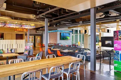 a restaurant with tables and chairs and a bar at Aloft Denver Airport at Gateway Park in Aurora