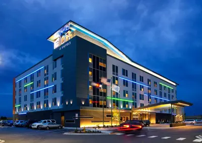 a hotel building with cars parked in a parking lot at Aloft Denver Airport at Gateway Park in Aurora
