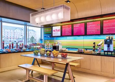 a restaurant with a table in front of a counter at Aloft Denver Airport at Gateway Park in Aurora