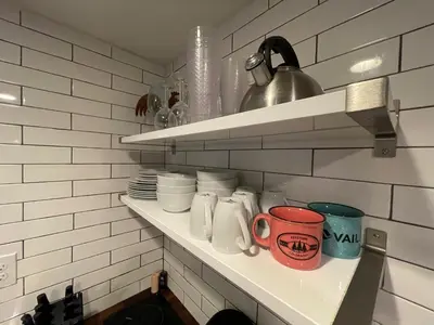 a kitchen shelf with cups and mugs on it at Launch Pad 2 Denver, Boulder & Mountains in Lafayette