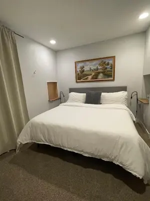a bedroom with a large white bed with a painting on the wall at Launch Pad 2 Denver, Boulder & Mountains in Lafayette