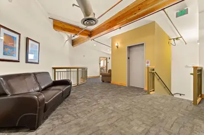 a living room with a couch and a hallway at Spacious Dtwn Estes Park Loft Condo 4 Mi to RMNP in Estes Park